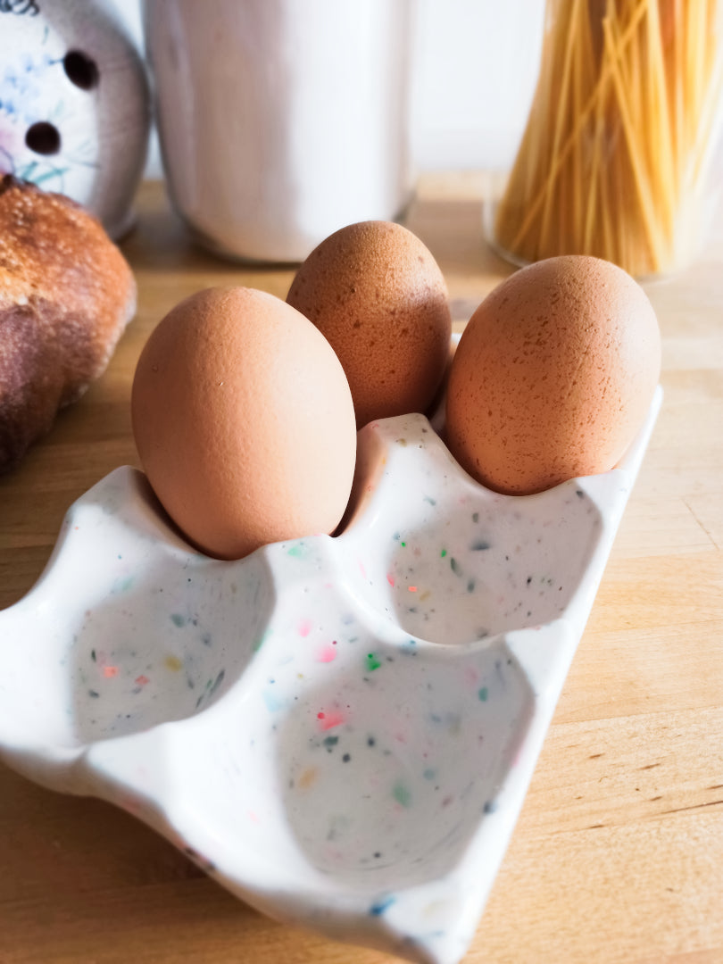 support à oeufs en jesmonite, blanc terrazzo multicolore, présenté avec de vrais oeufs, vue rapprochée