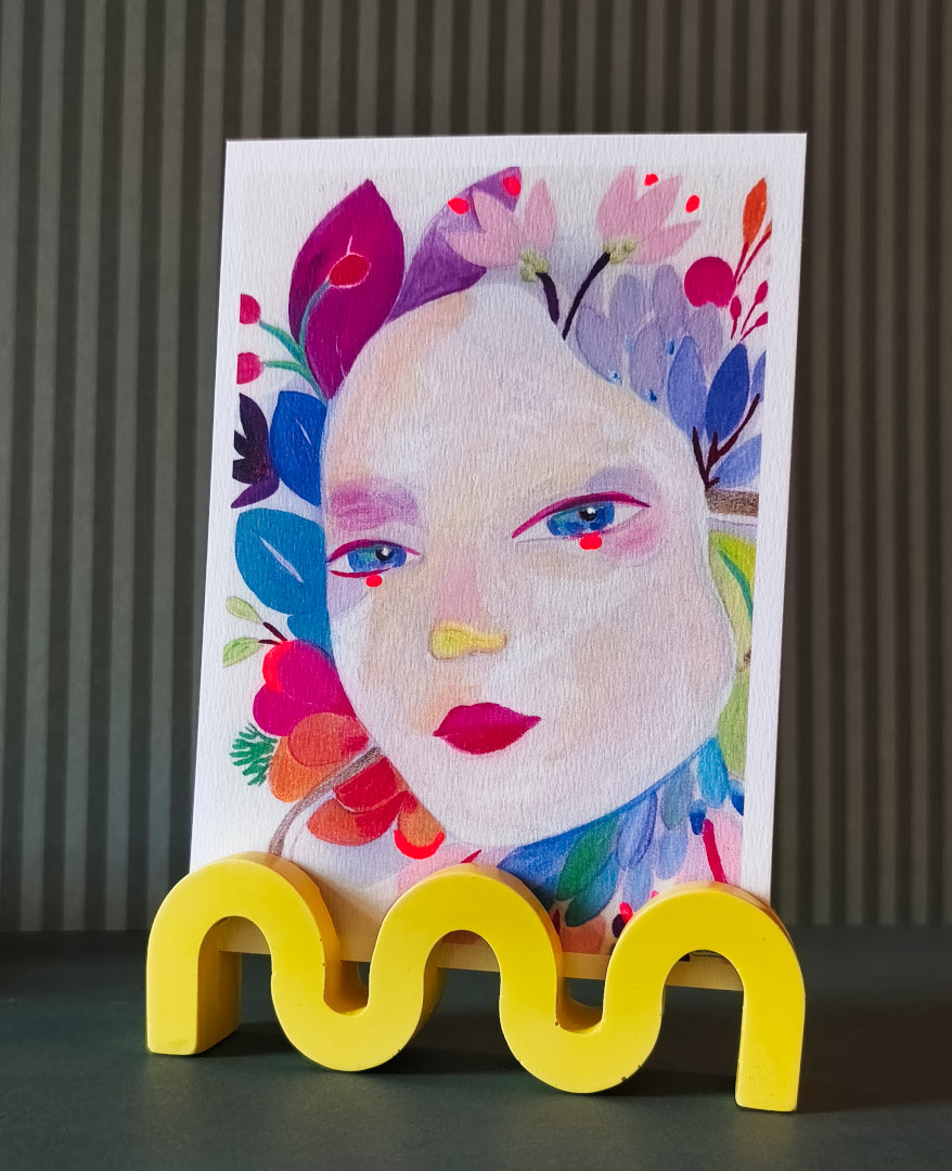 support photo wavy en jesmonite, couleur jaune, en forme de vague, présenté avec une carte postale d'izumi idoia