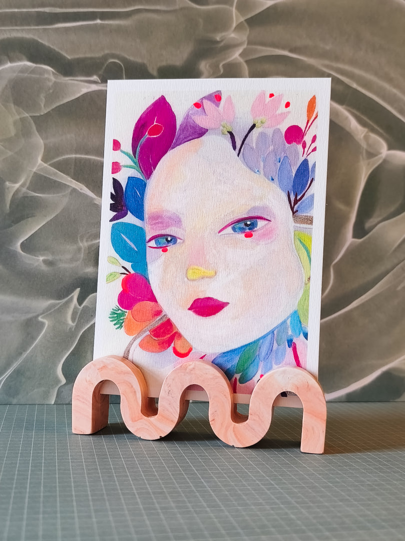 support photo wavy en jesmonite, en forme de vague, couleur orange marbré, présenté avec un carte postale d'izumi idoia
