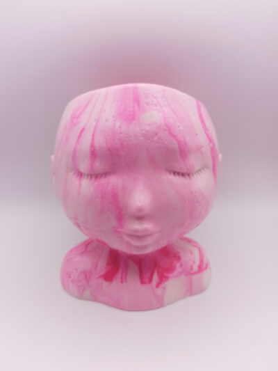 pot en forme de visage aux traits fins et délicats fabriqué en Jesmonite couleur rose fluorescent marbré