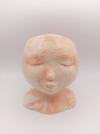 pot en forme de visage aux traits fins et délicats fabriqué en Jesmonite couleur orange marbré