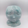 pot en forme de visage aux traits fins et délicats fabriqué en Jesmonite couleur bleu vert aqua marbré