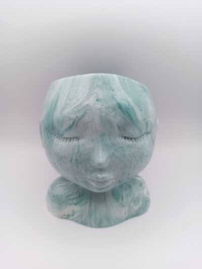 pot en forme de visage aux traits fins et délicats fabriqué en Jesmonite couleur bleu vert aqua marbré