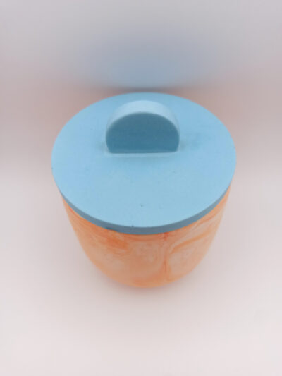 vue du dessus d'un petit pot en Jesmonite orange marbré et couvercle bleu clair design épuré lisse